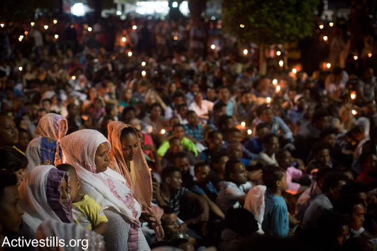Members of the Eritrean community in Israel hold a memorial service for a memorial ceremony for asylum seeker Habtom Zarhum in Levinsky park in south Tel Aviv, October 21, 2015. (Oren Ziv/Activestills.org)