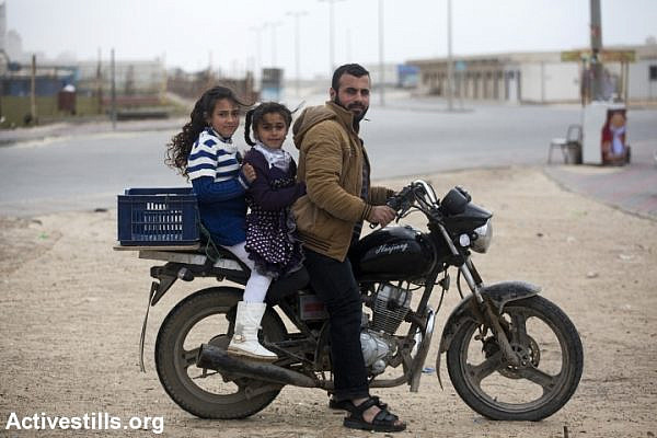 A Palestinian carries his two daughers on his motorcycle in the harbour of Gaza city, February 13, 2015. The sea remains one of the few open space where Palestinians can go and try to relax despite a very dire humanitarian situation and the trauma following the last summer Israeli military offensive. (photo: Anne Paq/Activestills.org)