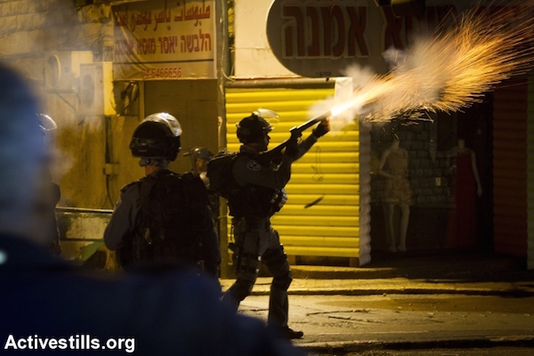 A special forces policeman fires tear gas at protesters during clashes between Israeli Police and Palestinians at a protest calling to protect Al-Aqsa Mosque in Nazareth, October 8, 2015. (Omar Sameer/Activestills)