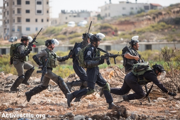 Israeli police and Border Police officers run toward Palestinian youths during clashes, October 12, 2015. (Yotam Ronen/Activestills.org)