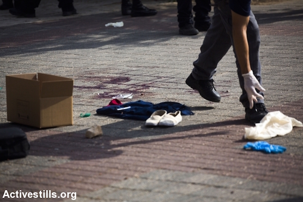 Israeli officials work on the site of a stabbing attack that injured two Israelis, near the Jerusalem Police station. The alleged assailant, reportedly a Palestinian school girl, was shot and seriously injured following the attack. Jerusalem, Oct 12, 2015. (Anne Paq/Activestills)