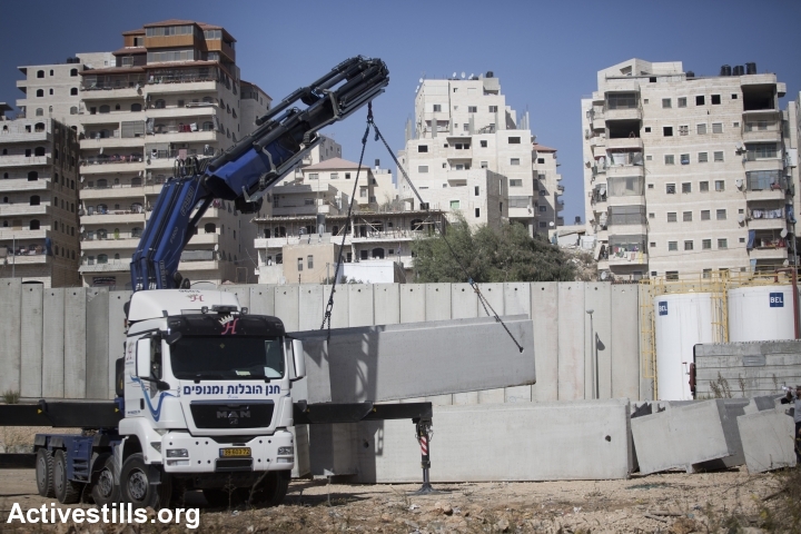 Building the separation barrier around Shuafat refugee camp, East Jerusalem, 2013. (photo: Oren Ziv/Activestills.org)