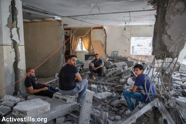 Palestinians from the Abu Jaber family sit on the ruins of their home that was demolished by Israeli authorities, East Jerusalem, October 6, 2015. The house belonged to the family of Ghassan Abu Jaber, who killed four worshippers in an attack on a synagogue last year. (photo: Yotam Ronen/Activestills.org)