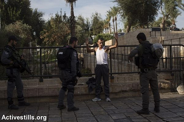 Israeli policemen search a Palestinian man at Damascus gate in Jerusalem's Old City, October 18, 2015. Israel set up checkpoints in the Palestinian neighborhoods of east Jerusalem and mobilized hundreds of soldiers as a collective punishment after recent attacks by Palestinians. (photo: Oren Ziv/Activestills.org)