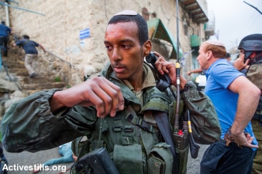  Israeli soldiers gather around the body of a Palestinian man who allegedly tried to stab a soldier at the Jewish settlement in the center of the Israeli-occupied city of Hebron, West Bank, on October 29, 2015. The city of Hebron has seen escalating violence in last weeks. (Yotam Ronen/Activestills)