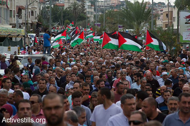 Palestinians with Israeli citizenship, some holding Palestinian flags, take part in a large protest during a general strike in solidarity with Palestinians in Jerusalem, West Bank and Gaza, in the northern town of Sakhnin, on October 13, 2015. Palestinians call for a Day of Rage following restrictions on Al Aqsa and recent violent attacks of both Israelis and Palestinians. (Activestills.org)