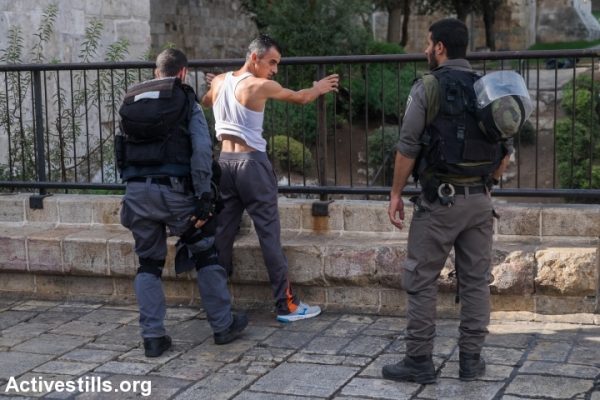 Israeli policemen search a Palestinian man at Damascus gate, in Jerusalem's old city, October 18, 2015. (Yotam Ronen/Activestills.org)