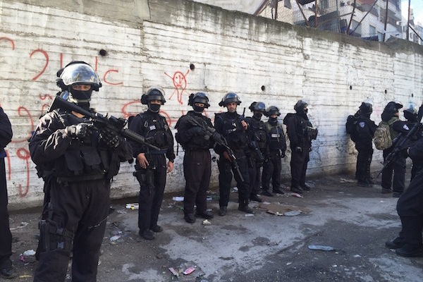Israeli security forces line up in a street in Shuafat refugee camp during a home demolition, East Jerusalem, December 2, 2015.
