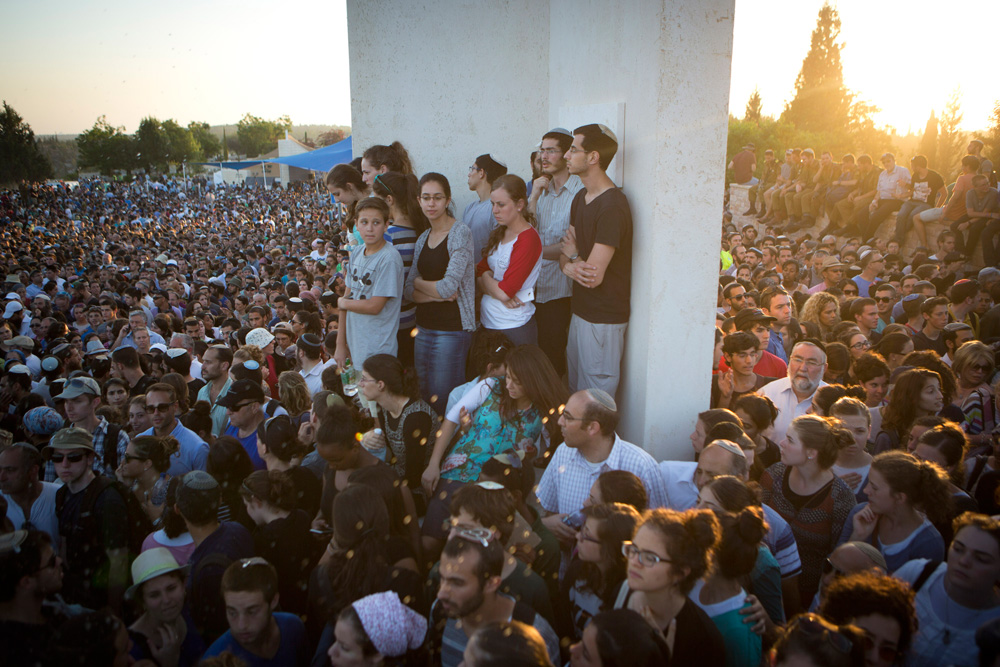 Thousands of Israelis mourn at the funeral of Eyal Yifrah, Gilad Shaar, and Naftali Fraenkel, the three Israeli teenagers who were kidnapped and murdered in the West Bank, July 1, 2014. (Activestills.org)