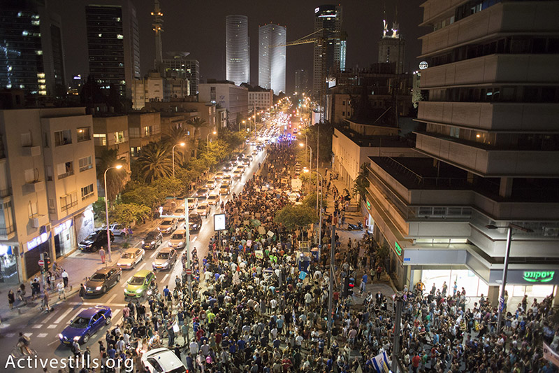 Protesters shout slogans as they block road during a protest against natural gas privatisation in Tel Aviv, June 27, 2015. Around 4000 people marched in protest of the government's policies regarding the privatisation of natural gas found in the Mediterranean sea.  Activestills.org