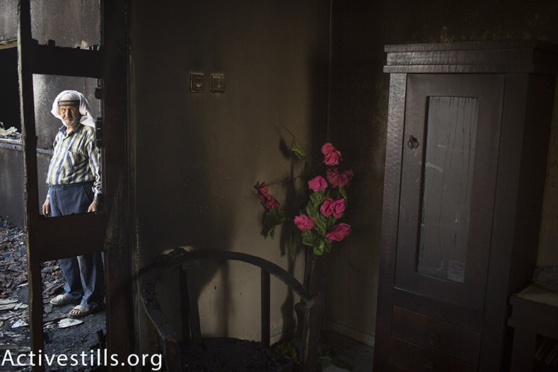 Palestinian man looks at the damaged house of the Dawabsha family, which was set on fire by Jewish settlers and where 18-month-old Palestinian toddler Ali Saad Dawabsha died, in the West Bank village of Duma, on July 31, 2015. The Palestinian toddler was burned to death and four family members injured in an arson attack on two homes in the occupied West Bank. Activestills.org 