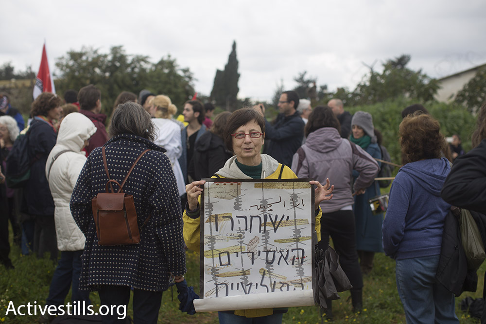 A woman holds a sign reading ‘Free the political prisoners’ at a protest in solidarity with Israeli conscientious objector Tair Kaminer, Prison 400, central Israel, January 23, 2016. (Oren Ziv/Activestills.org)
