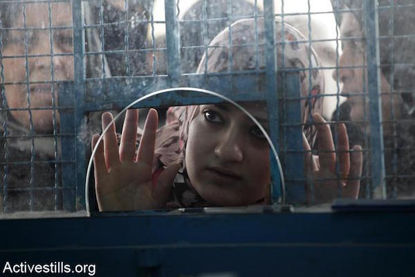 A Palestinian woman waits to receive food vouchers at an UNRWA distribution center in the Al-Tuffah neighborhood of Gaza, February 2012. According to Israeli human rights group Gisha, some 70 percent of Gazans rely on humanitarian aid. (Anne Paq/Activestills.org)