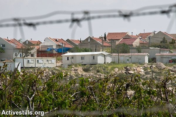 Mobile homes and fruit trees represent the expanding edges of the Israeli settlement of Ma'on, which is taking land from the South Hebron Hills village of Al Tuwani, West Bank, April 2, 2014. (Ryan Rodrick Beiler/Activestills.org)