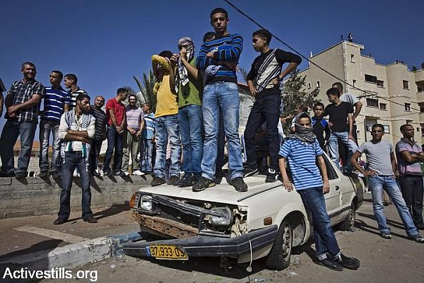 Palestinian citizens of Israel stand on a car during clashes in Umm al Fahm, Israel, October 27, 2010. (photo: Oren Ziv/Activestills.org)