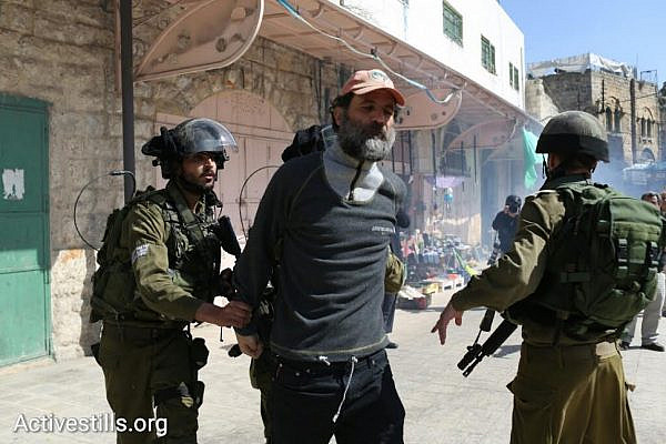 Israeli soldiers arrest activist Kobi Snitz during a protest in Hebron marking 22 years since the Ibrahimi Mosque Massacre, February 20, 2016. (photo: Oren Ziv/Activestills.org)