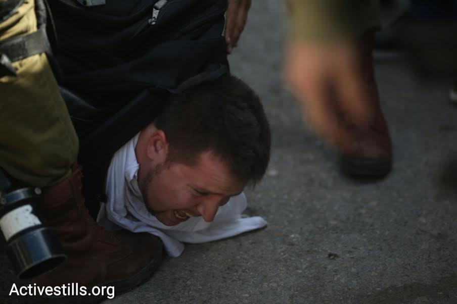 Israeli soldiers pin down and arrest an Israeli activist during a demonstration in central Hebron, February 20, 2016. (photo: Oren Ziv/Activestills.org)