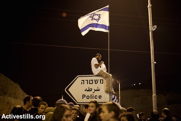 Right-wing Israeli settlers demonstrate after marching from Ma'aleh Adumim settlement to the E1 area on the eastern outskirts of Jerusalem, during a protest calling for an expansion of Jewish settlements in E1, West Bank, February 13, 2014. (Activestills)