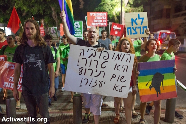 Israeli left-wing activists protest against recent Jewish violent attacks on the Dawabsha family and LGTBQ activists, Tel Aviv, August, 8, 2015. The protesters are holding signs saying "Homophobia is terror," "Do not murder" and "Homophobia and racism are the same violence." (Yotam Ronen/Activestills.org)
