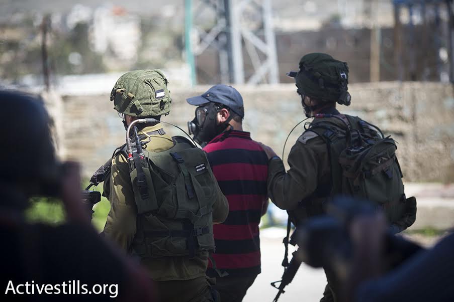 Israeli soldiers arrest a Palestinian photographer during a demonstration in the West Bank city of Hebron, February 26, 2016. (photo: Oren Ziv/Activestills.org)