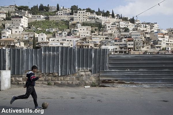 A Palestinian child plays next to a wall in the East Jerusalem neighborhood of Silwan, February 21, 2016. (Activestills.org)