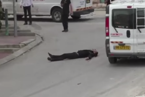 A Palestinian man seen laying on the ground seconds after being shot in the by an IDF soldier. (YouTube screenshot)
