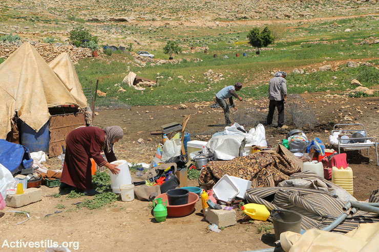 Residents of Khirbet Tana sort through the rubble to salvage their belongings after Israeli military forces demolished over a dozen structures just hours earlier, Jordan Valley, West Bank, January 23, 2016. (Ahmad Al-Bazz/Activestills.org)