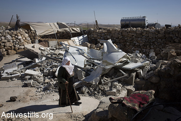 A Palestinian woman walks next to her demolished home after it was tear down by Israeli bulldozers in the village of Khirbet al-Halawah in the 918 military zone, which includes several villages, south of Hebron, West Bank, February 2, 2016. Israeli forces demolished at least a 23 buildings in the military zone in the southern West Bank, leaving several families homeless. Israel has carried out a long campaign to relocate the residents of the area, which was declared a military zone by the Israeli government in the 1970's. (Activestills.org)