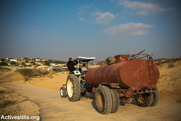 Residents of Umm el-Hiran tow potable water to their village, Umm el-Hiran. Israeli authorities have refused to connect unrecognized villages like Umm el-Hiran to the country’s national water and electricity grids, and refuse to provide them with the most basic services. (Activestills.org)
