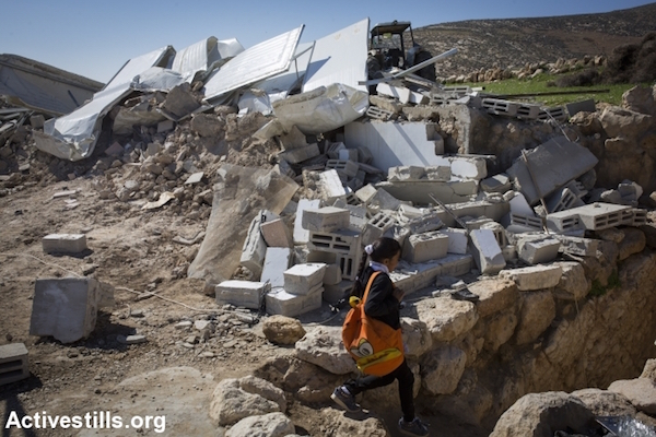 A Palestinian girl walks back from school to her demolished home after it was torn down by Israeli bulldozers in the village of Khirbet al-Halawah in firing zone 918, which includes several villages, south of Hebron, West Bank, February 3, 2016. Israeli forces demolished at least a 23 buildings in the military zone in the southern West Bank, leaving several families homeless. Israel has carried out a long campaign to relocate the residents of the area, which was declared a military zone by the Israeli government in the 1970s.