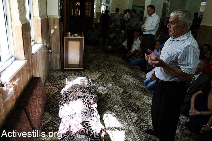  The body of Hadeel al-Hashlamon, a 18-year old Palestinian woman who was shot by Israeli soldiers in a checkpoint in the West Bank city of Hebron, surrounded by relatives during her funeral, September 23, 2015. Israeli army spokesperson claimed al-Hashlamo tried to stab a solider, while human rights groups claim she was shot without being a threat to the soldiers at the checkpoint. (Activestills.org)