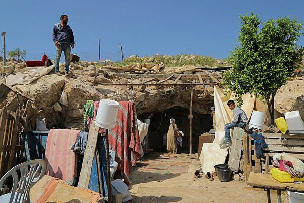 Palestinian residents of Khirbet Tana examine the damage after Israeli military forces demolished a number of structures in the village earlier in the day, West Bank, April 7, 2016. (Ahmad al-Bazz / Activestills.org)