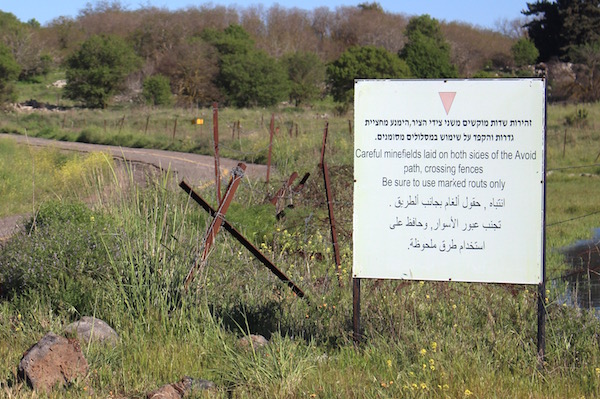 A sign warns of minefields on either side of the road leading to the destroyed Circassian village of Sur'aman, Golan Heights, April 1, 2016. (Natasha Roth)