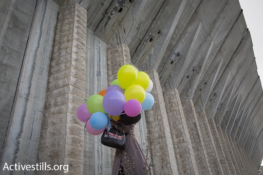 A Palestinian woman carries balloons during a peace march along the West Bank’s major north-south artery, Highway 60. (Oren Ziv/Activestills.org)