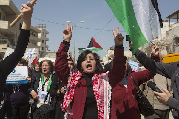 Palestinian women protest against the occupation on International Women’s Day at the Qalandiya military checkpoint separating Jerusalem and Ramallah, March 7, 2015. (Anne Paq/Activestills.org)