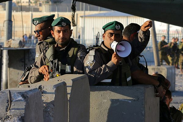 Israeli Border Police direct Palestinian worshipers through the Qalandiya checkpoint separating Ramallah and Jerusalem on their way to pray at Al-Aqsa Mosque for the second Friday of Ramadan, June 17, 2016. (Ahmad Al-Bazz/Activestills.org)