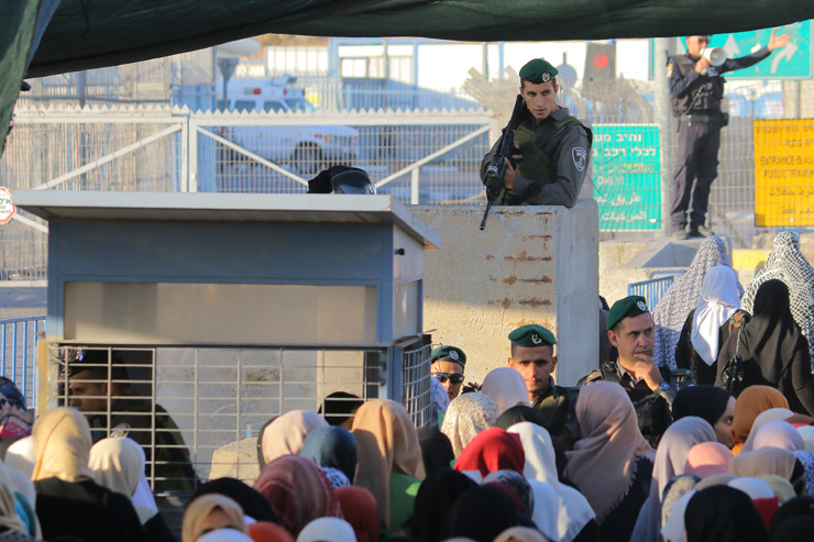 Palestinian worshipers enter the Israeli military’s Qalandiya checkpoint separating Ramallah and Jerusalem on their way to pray at Al-Aqsa Mosque for the second Friday of Ramadan, June 17, 201-. (Ahmad Al-Bazz/Activestills.org)