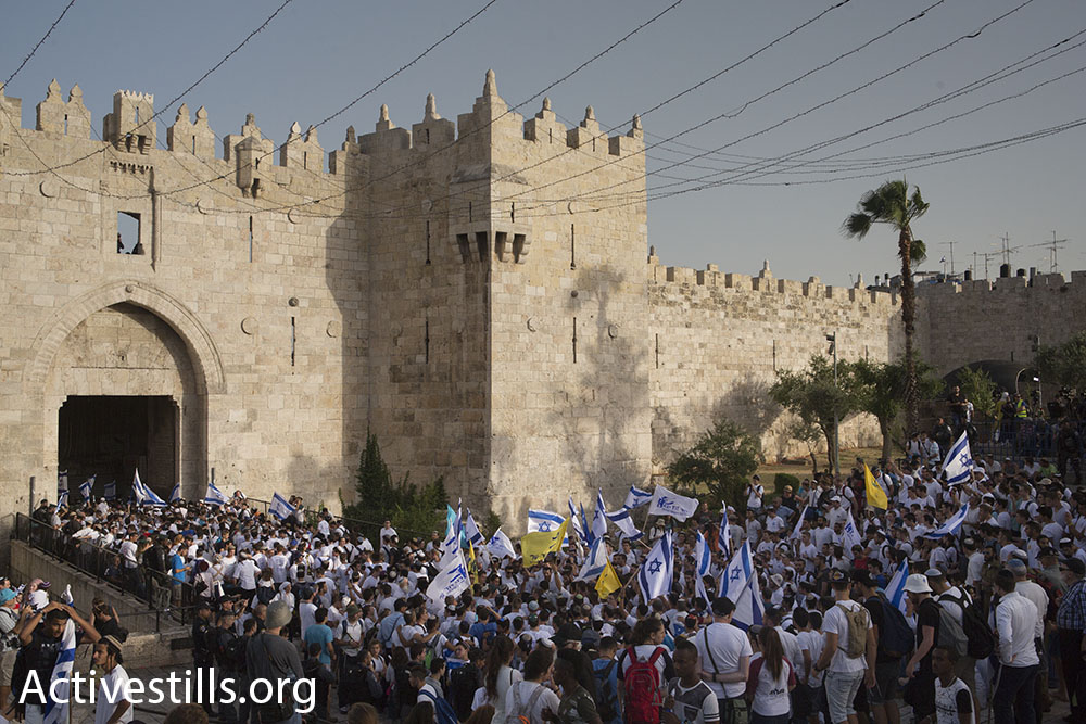 Nationalist Jewish Israelis, largely bussed-in yeshiva students, enter the Muslim Quarter of Jerusalem’s Old City through Damascus Gate on Jerusalem Day, June 5, 2016. (Oren Ziv/Activestills.org)