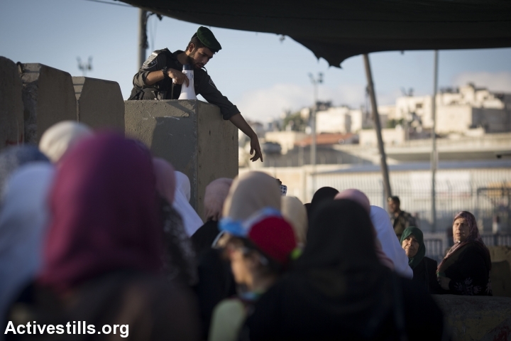 Palestinian women enter an Israeli military checkpoint on their way to Al-Aqsa Mosque for prayers on the first Friday of Ramadan, June 10, 2016. Men and women over the age of 45 were allowed to visit the mosque but Israeli authorities suspended some 83,000 entry permits issued for the Muslim holiday in response to a shooting attack in Tel Aviv. (Oren Ziv/Activestills.org)