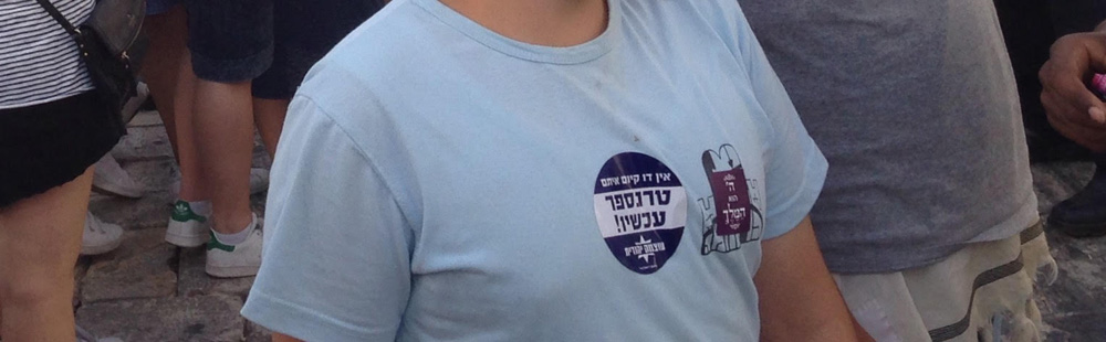 The sticker, seen on a young participant in the Jerusalem Day parade through East Jerusalem, reads: ‘There is no coexistence with them; Transfer now; Otzma Yehudit (a political party)’, June 5, 2016. (Moriel Rothman-Zecher)