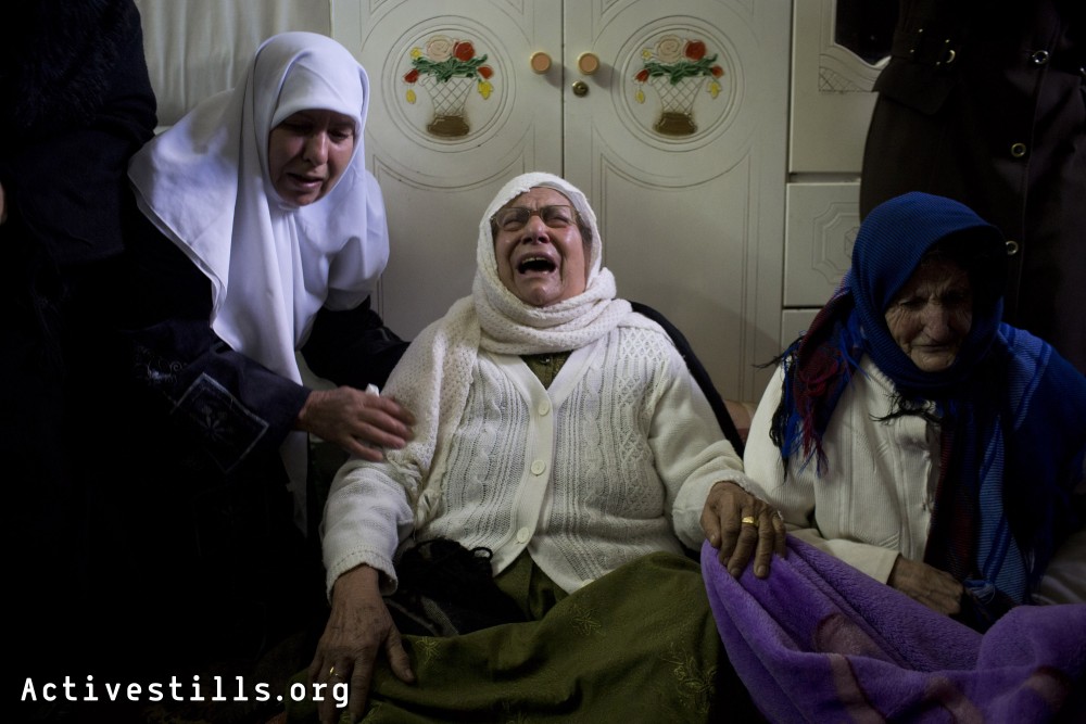 Relatives of Said Jasir, 85 years old who died from inhalation of tear gas shot by the Israeli army into his home, mourn during his funeral in the West Bank village of Kfar Qaddum, January 2, 2014. 