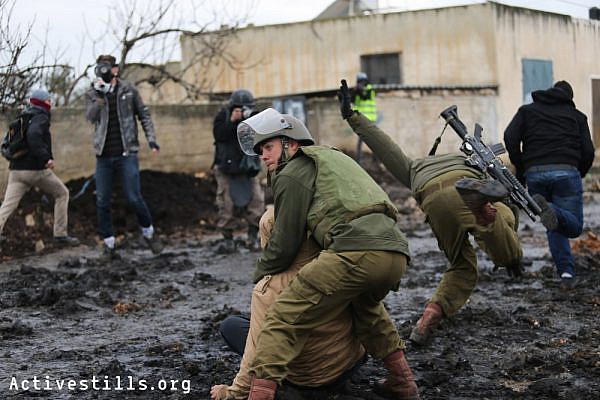 Israeli soldiers arrest a Palestinian youth during the weekly protest against the occupation, in the West Bank village of  Kafr Qaddum, January 16, 2015.
