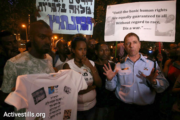 A police commander tells demonstrators at a protest against police brutality targeting Israelis of Ethiopian descent that he will release 12 arrestees if the protesters disperse, July 3, 2016. (Oren Ziv/Activestills.org)