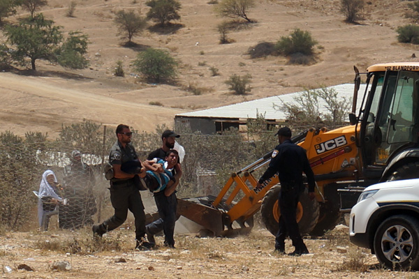 Police arrest a youth from Umm el-Hiran as construction crews prepare to build a fence around village homes, July 31, 2016. (Negev Coexistence Forum for Civil Equality)