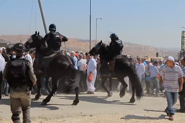 Mounted Israeli Border Police charge a crowd of Palestinians hoping to cross into Jerusalem to pray at al-Aqsa Mosque, July 1, 2016. (Screenshot/Activestills.org)