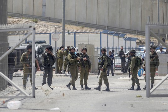 Israel soldiers and private security guards at the Qalandiya checkpoint shortly after the two siblings were shot, April 27, 2016. (Yonatan Sindel/Flash90) 