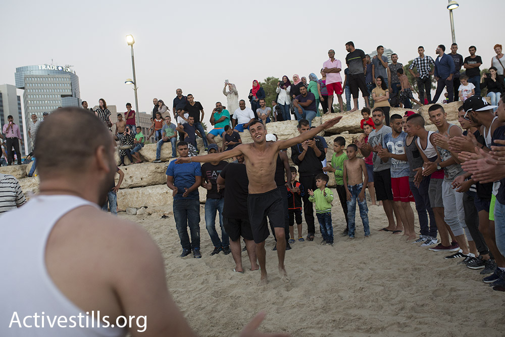 Young Palestinian men perform a traditional dabke dance on the beach in Jaffa during Eid al-Adha, September 14, 2016. (Oren Ziv/Activestills.org)