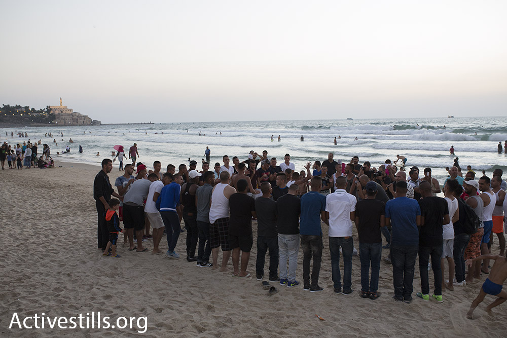 Young Palestinian men gather in a square to perform the dabke dance on the beach in Jaffa during Eid al-Adha, September 14, 2016. (Oren Ziv/Activestills.org)