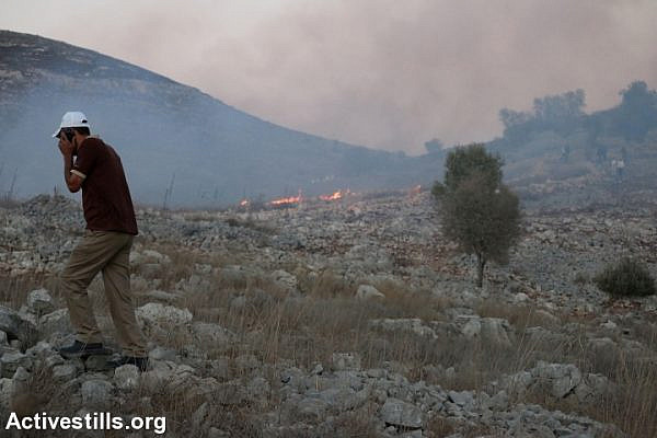 Palestinian farmers clash with Israeli settlers after they set fire to Palestinian agricultural fields in Burin village near Nablus, October 3, 2015. (Ahmad Al-Bazz/Activestills.org)