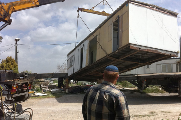 A Jewish settler watches as a caravan home in the illegal outpost of Ramat Gilad is removed, after which it was relocated in a another West Bank settlement March 14, 2012. (Roy Sharon/Flash90)